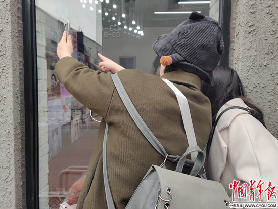 　　1月11日，第一届中国站姐大会会场橱窗外，两名早到的粉丝看到墙上爱豆（idol，意为偶像）的照片尖叫不已。中青报·中青网见习记者 张艺/摄