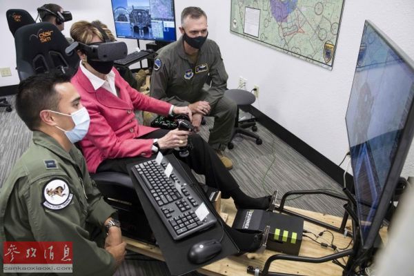 资料图片：美空军部长芭芭拉·巴雷特（中）在考察“飞行学员训练2.5倡议”计划时试用了学员们在飞行模拟器上使用的虚拟现实眼镜。(美国空军网站)