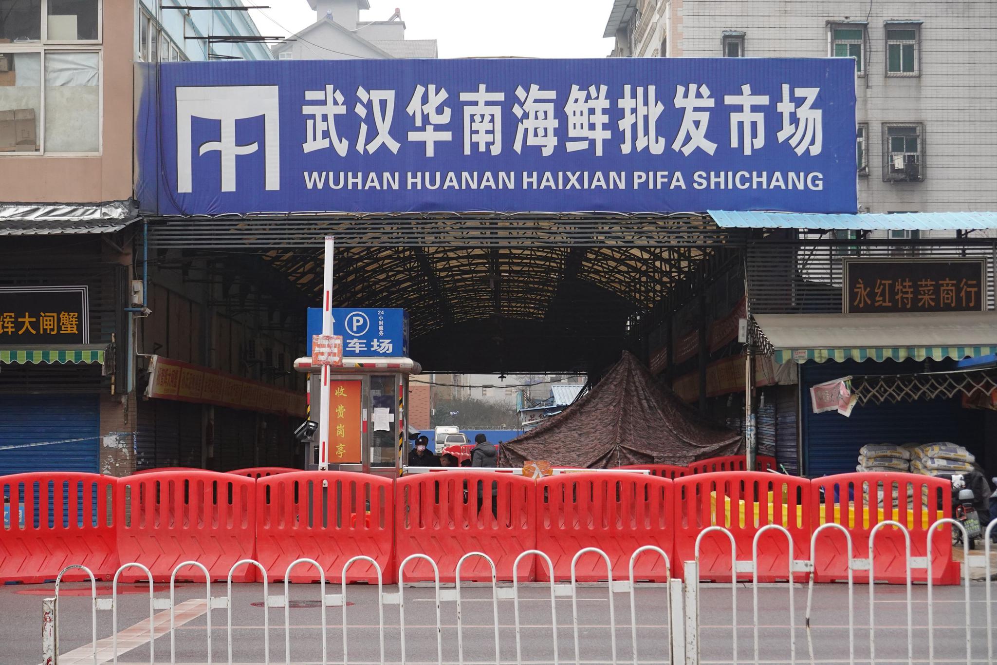  1月21日16时许，武汉华南海鲜批发市场大门西南侧东区五街通道已关停，当地警方在现场拉起警戒线。新京报记者 游天燚 摄