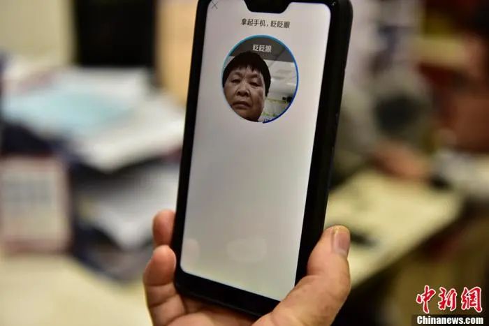  退休老人在用手机刷脸认证养老金领取资格。图片来源：CNSPHOTO