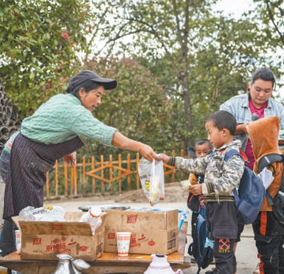 　　村民在村口卖早点。　　李建生摄