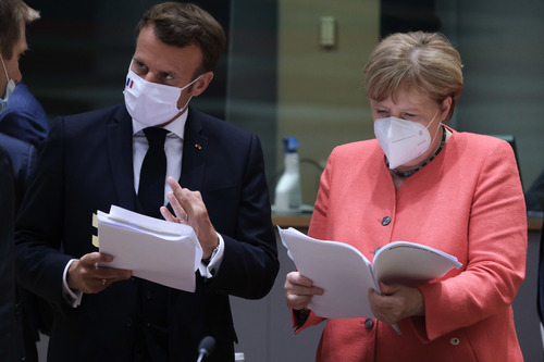 7月20日，在比利时布鲁塞尔的欧盟总部，法国总统马克龙（左）和德国总理默克尔准备出席欧盟峰会。新华社发（欧盟供图）