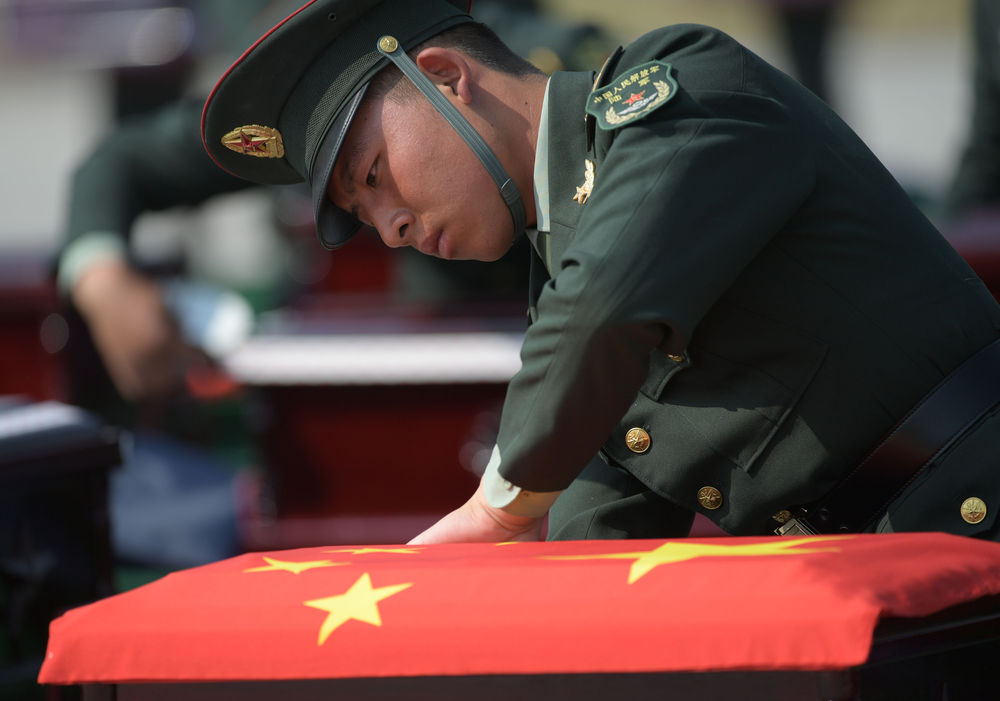 9月27日,在沈阳桃仙国际机场,礼兵在殓放志愿军烈士遗骸的棺椁上盖上国旗。当日,第七批在韩中国人民志愿军烈士遗骸由中国空军专机护送从韩国接回辽宁沈阳。新华社记者 杨青 摄