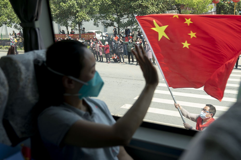 4月15日,武汉市民挥舞国旗,送别北京协和医院国家援鄂抗疫医疗队。新华社记者 熊琦 摄