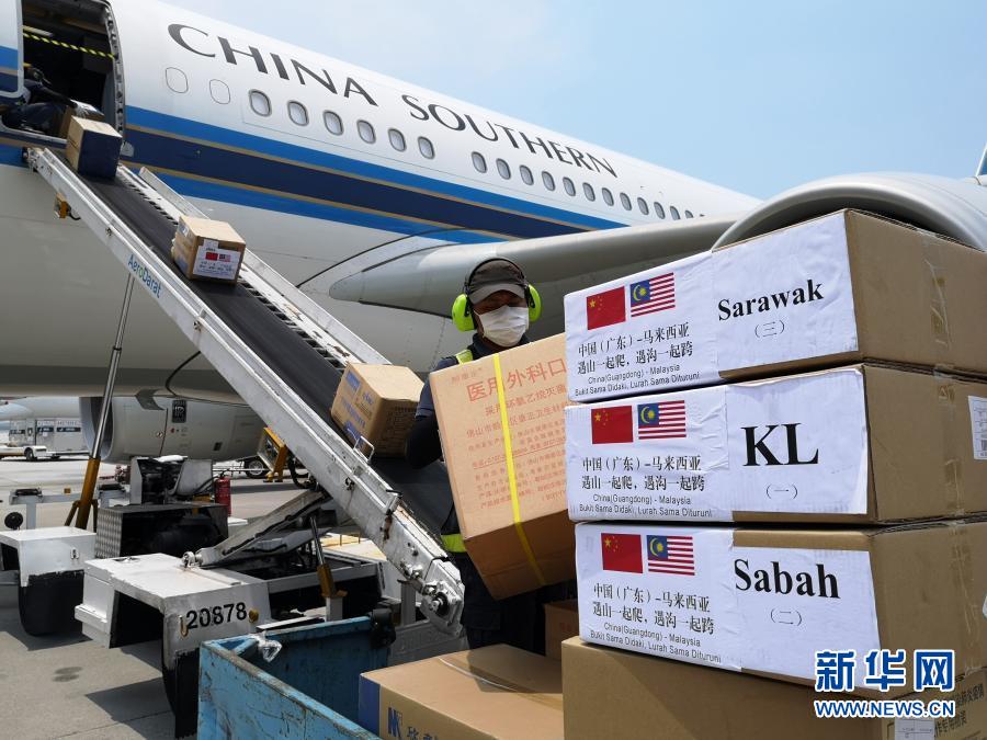 4月18日,在马来西亚吉隆坡国际机场,地勤人员搬运中国政府向马来西亚派遣的抗疫医疗专家组带来的物资。新华社发(中国驻马来西亚大使馆供图)