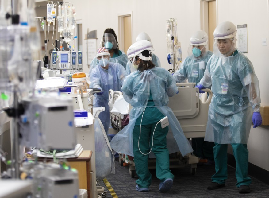 △加利福尼亚州一间医院里的医护人员将新冠肺炎患者推入病房 图片来源：《洛杉矶时报》