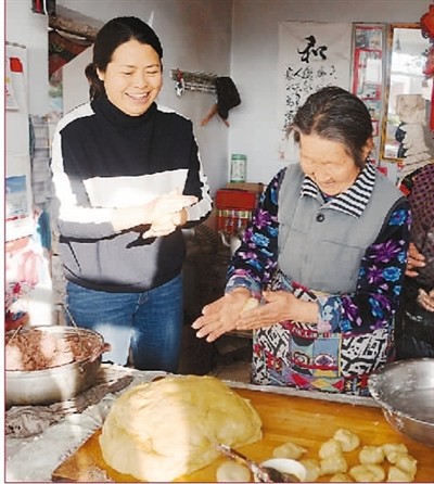 　　王会敏（左）到村民家包馅糕。　　赵占南摄