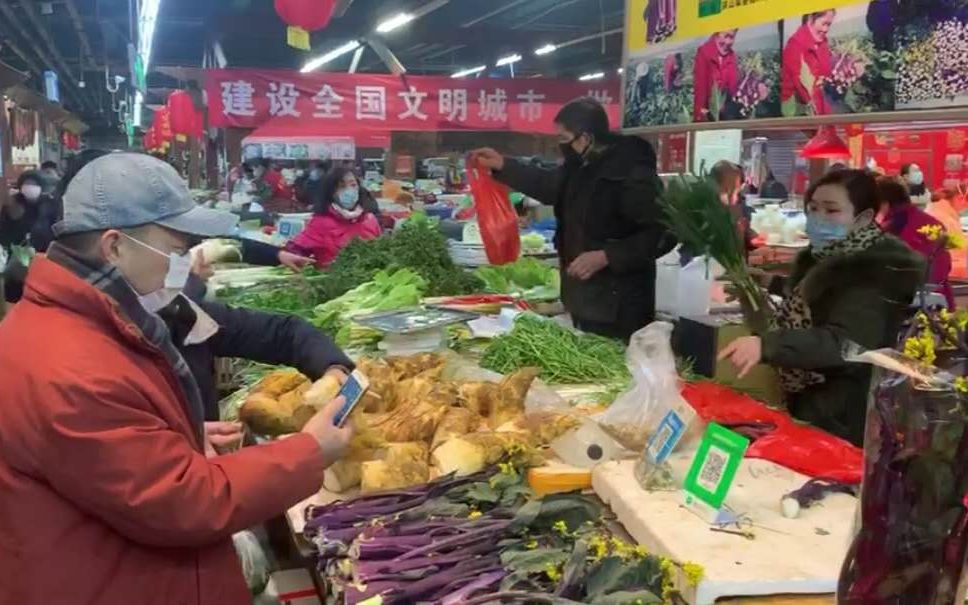 1月23日武汉市民去菜市场购买蔬菜。视频截图