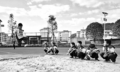 贵州省黔西南州望谟县实验小学学生在新操场上体育课。钱凌芸摄/光明图片