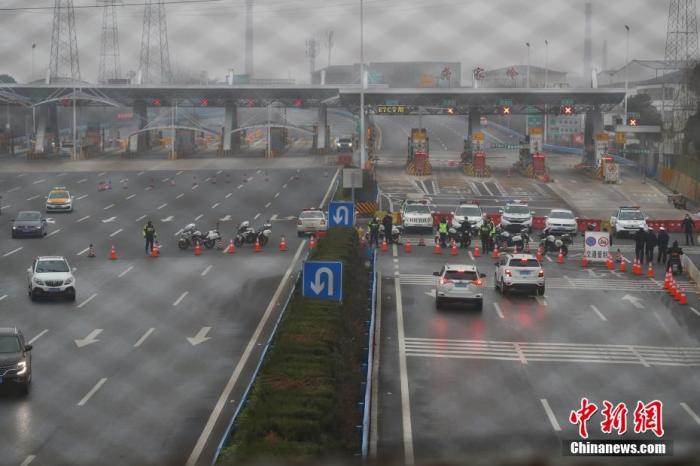 1月23日，警方在武汉市洪山区武鄂高速公路(龚家岭收费站)进行交通管制。中新社记者 张畅 摄