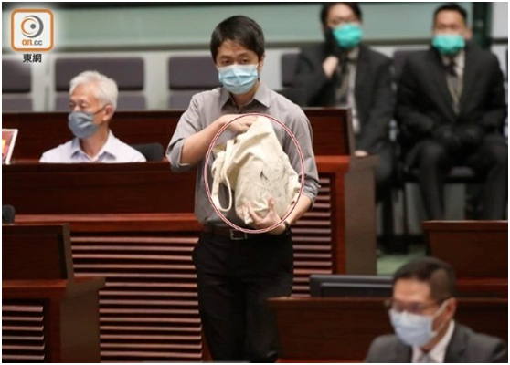 ·5月28日，许智峰手持“臭弹”走近主席台。（图源：香港“东网”）