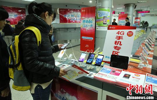 资料图:市民在了解手机功能。中新社发 熊然 摄