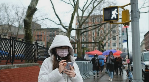 美国纽约市唐人街一女子戴口罩出行（英国《每日邮报》网站）