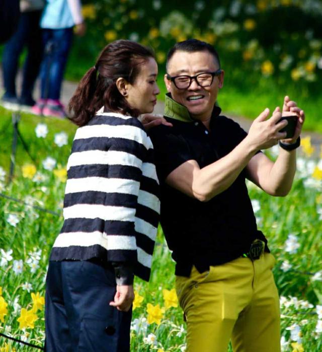 周立波胡洁夫妻又秀恩爱,都穿黑色羽绒服都戴帽子,时尚又减龄