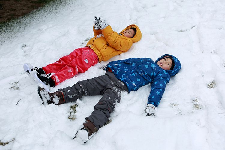 幼至交躺在雪地上抬看天空。