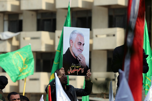 1月4日，在伊拉克巴格达，哀悼者举着伊朗伊斯兰革命卫队下属“圣城旅”指挥官卡西姆·苏莱曼尼的画像参加送葬活动。新华社发