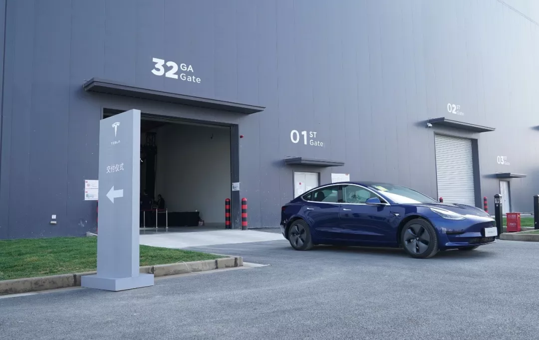 12月30日,一辆完成交付的特斯拉Model 3汽车驶出工厂车间(新华社记者 方喆 摄)