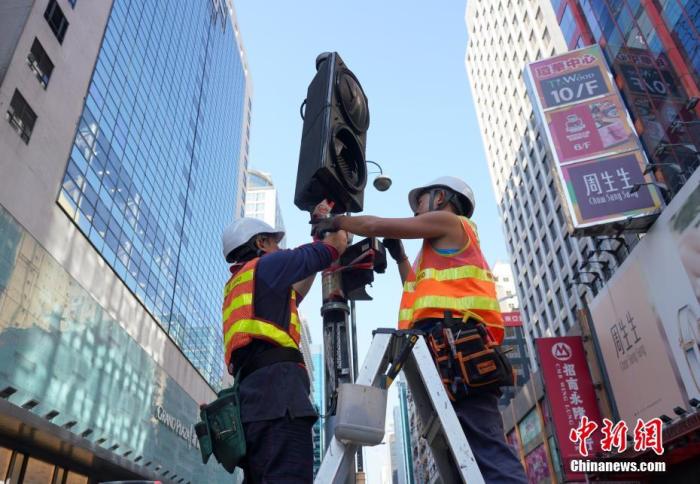 资料图:工程人员正在香港旺角弥敦道抢修早前被示威者破坏的交通信号灯。中新社记者 张炜 摄