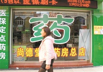一位市民从一家药店的“药”字前经过。 徐仲庭 摄/人民图片
