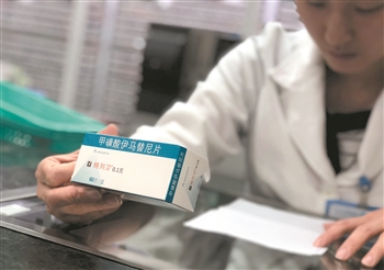 在广东省人民医院，一名药师正遵照医嘱核对抗癌药物“格列卫”。 新华社 发