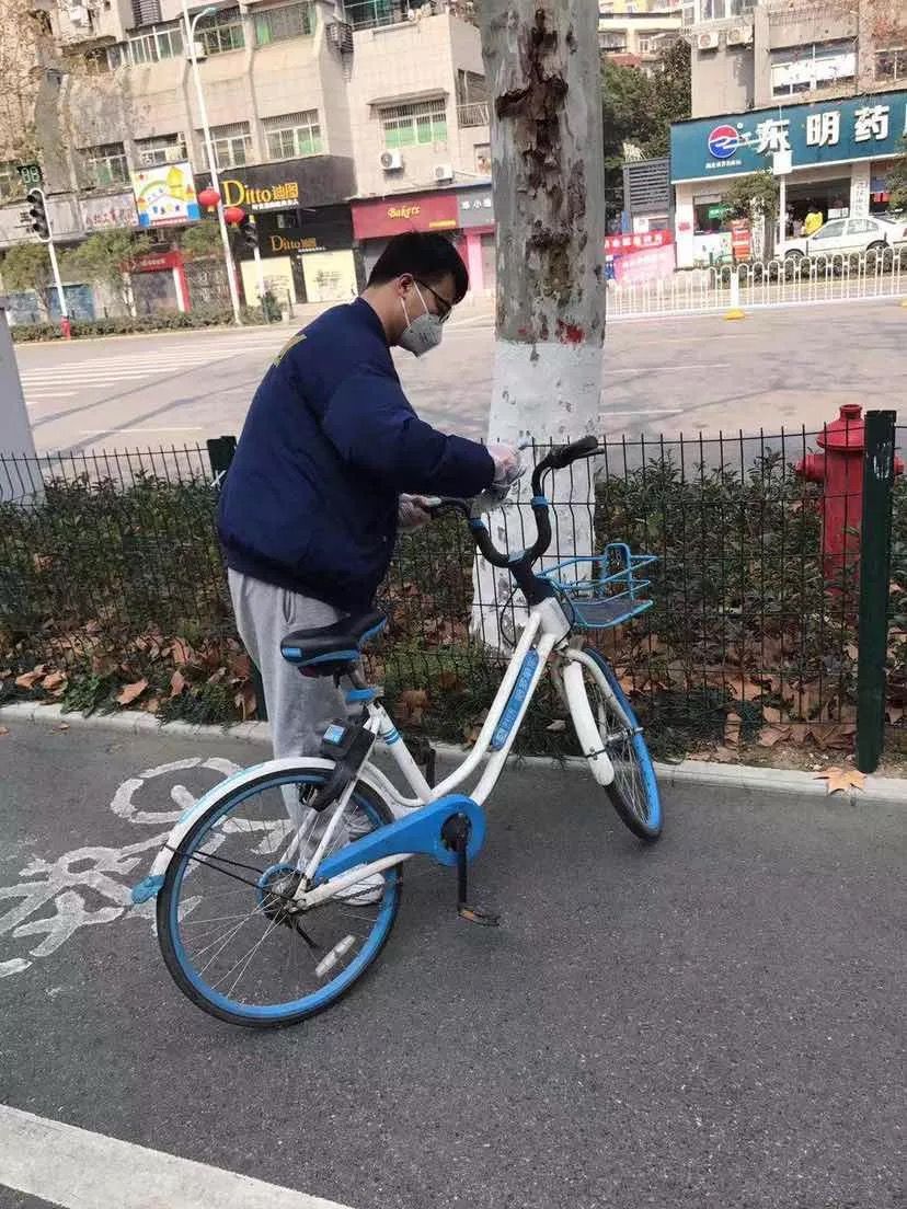 图为正在为哈啰单车消毒的于海涛。