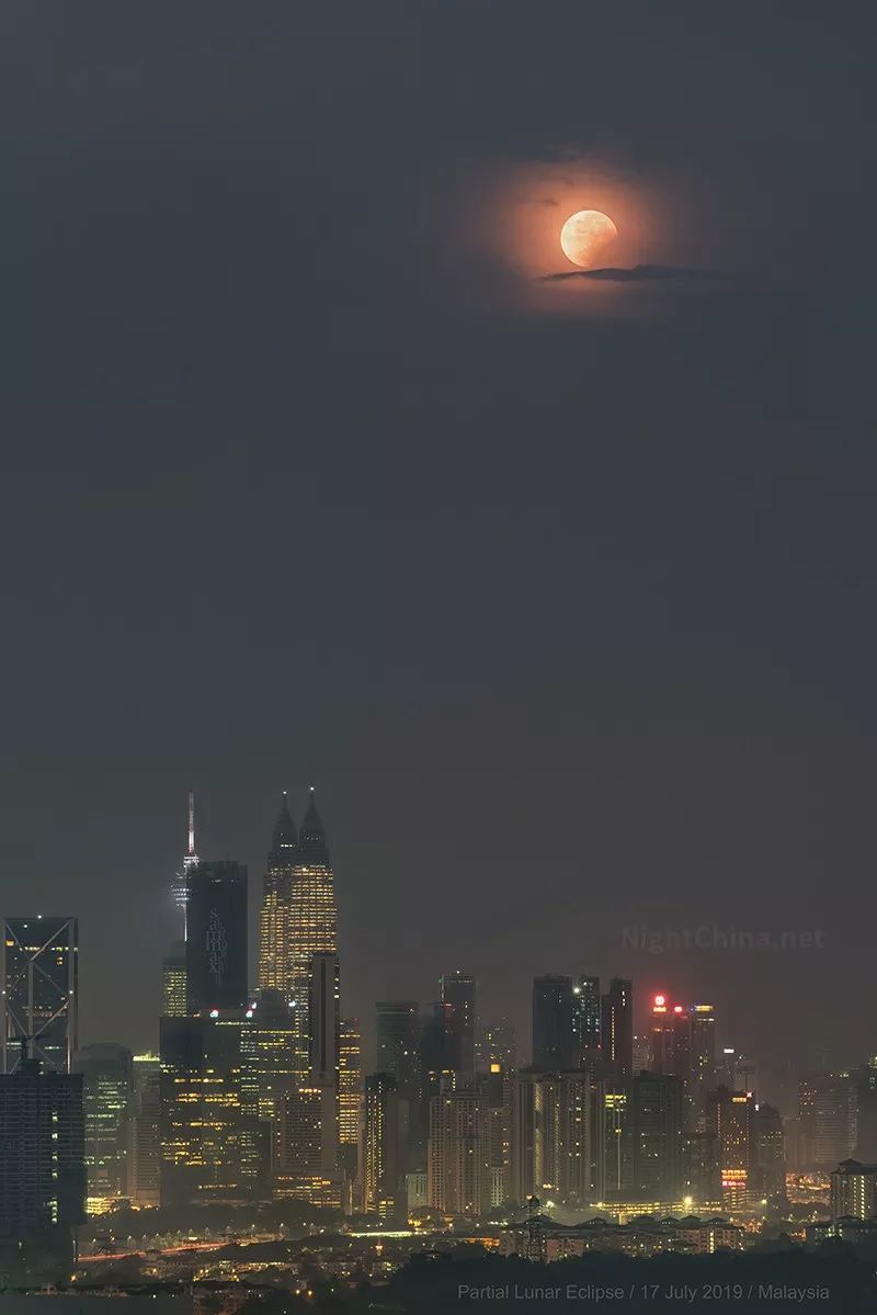 月偏食下的城市天际线夜空中国