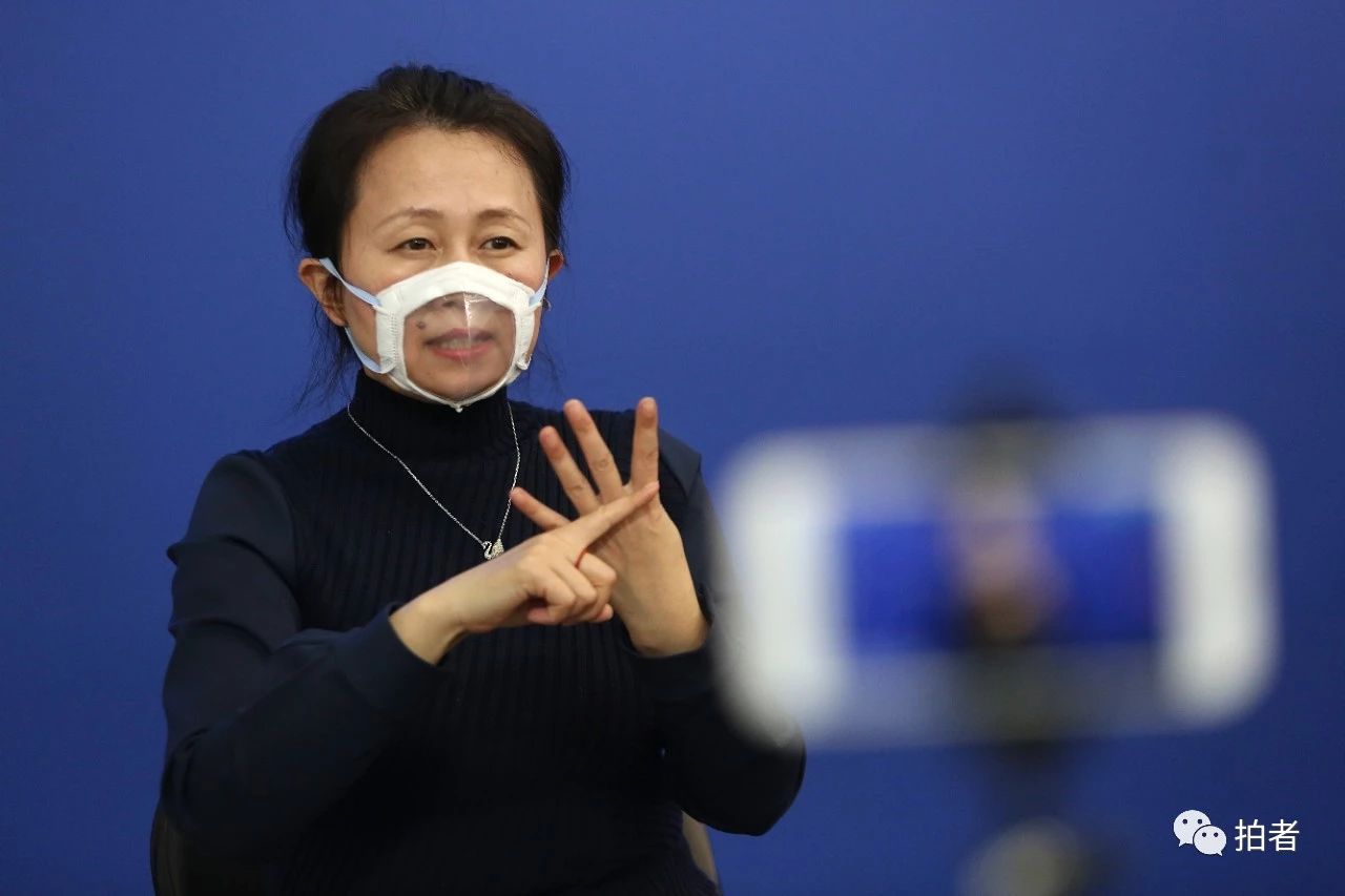 新冠肺炎疫情防控工作新闻发布会上,一名手语翻译佩戴特制的口罩以便