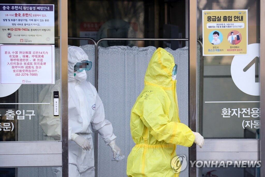 资料图：2月6日，在首尔医疗中心，医疗人员身穿防护服走出急诊中心。 （来源：韩联社）