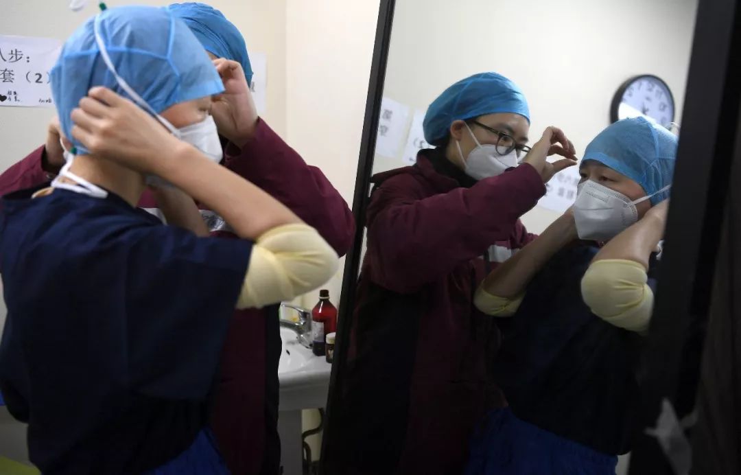 武汉协和医院（西院），湘雅医院感染病科医生在穿防护衣。经济日报记者高兴贵摄