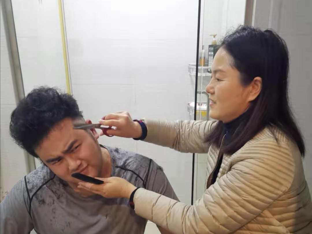 2月10日,高容峰母亲正在给他在家理发.
