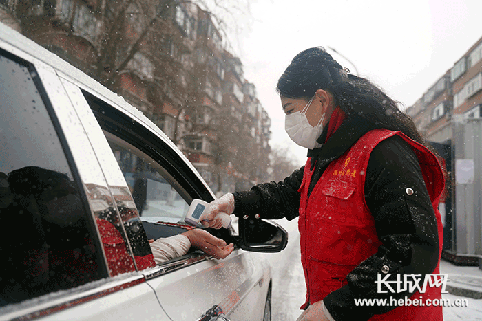 　　陈林静正在对车内让人员测体温。长城新媒体记者 邢丁 摄