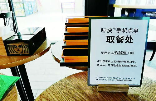 商场的星巴克店内，顾客需通过手机App点单后在专门的取餐处取餐。