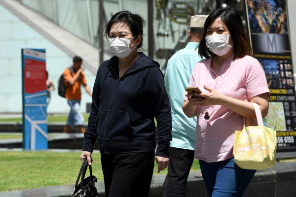 两名佩戴防护口罩的女士在新加坡街头。（法新社）