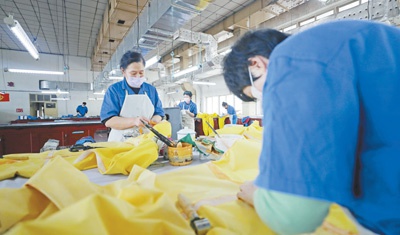 中国化工集团沈阳橡胶研究设计院有限公司员工加班生产隔离服。 　　新华社记者 杨 青摄
