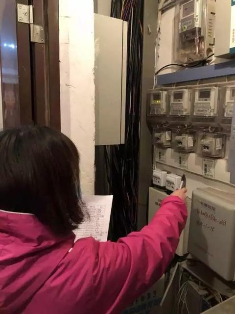 武汉洪山区金色城市社区，工作人员查看电表，对照入住登记表核实信息