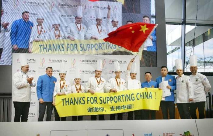 中国青年队上台领奖打出横幅,对组委会和各国朋友表示感谢。中国烹饪协会供图