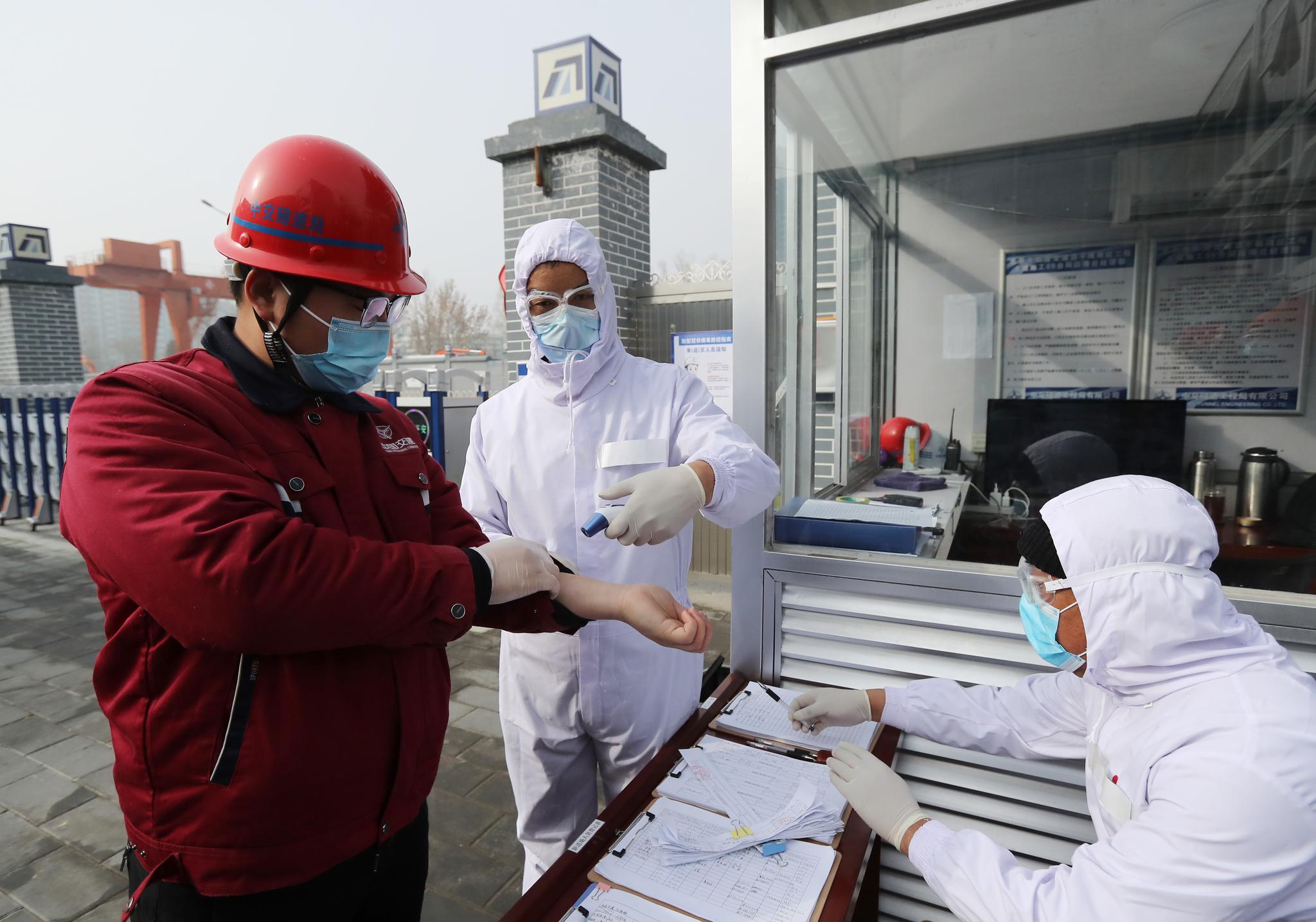 进入工地时,需要测量体温.摄影/新京报记者 王贵彬