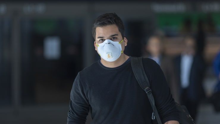 美國洛杉磯一名戴口罩的路人。圖源：CNBC