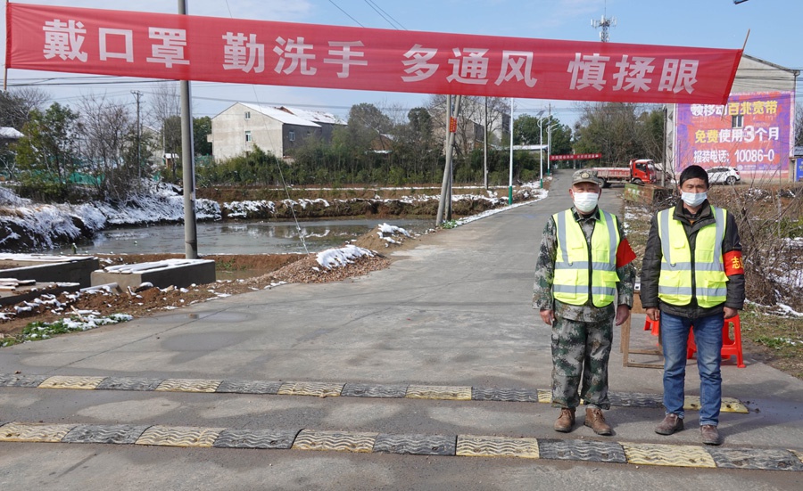2月16日,在武汉市蔡甸区张湾街黄土坡村,村民自觉者在路口执勤,黄土坡村这个路口也是进出新民村的必经之路,两个村子相邻。 新华社 图