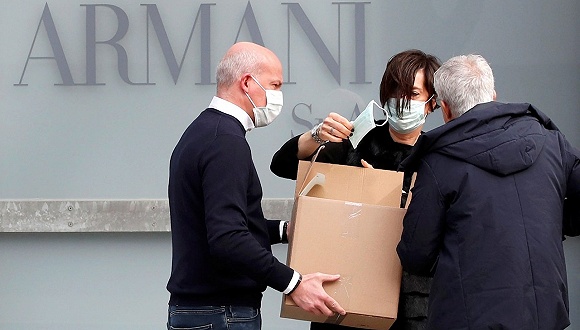 在Giorgio Armani米兰时装周的秀场外，工作人员带起了口罩。图片来源：路透社