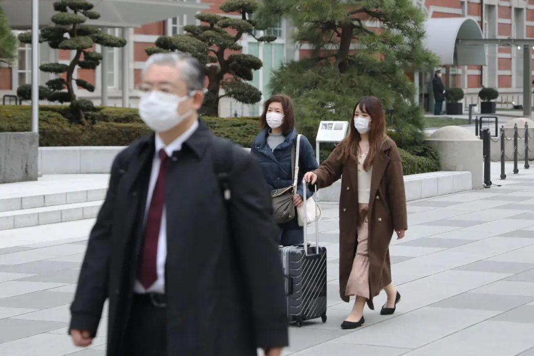  2月25日，在日本东京，人们戴口罩出行。
