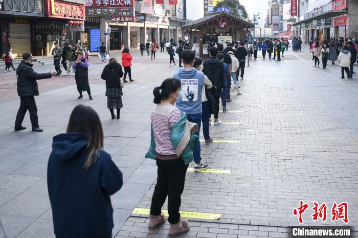 长沙市黄兴路步行街一奶茶店开张，戴着口罩的市民有序排队购买。　杨华峰 摄