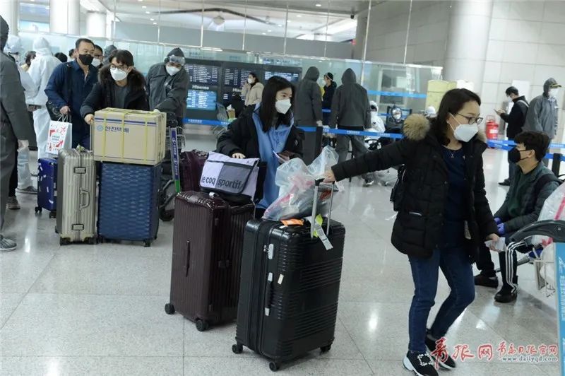  2月25日，由韩国抵达青岛流亭国际机场的乘客在完成相关登记手续后分区市离开。记者 傅学军 摄