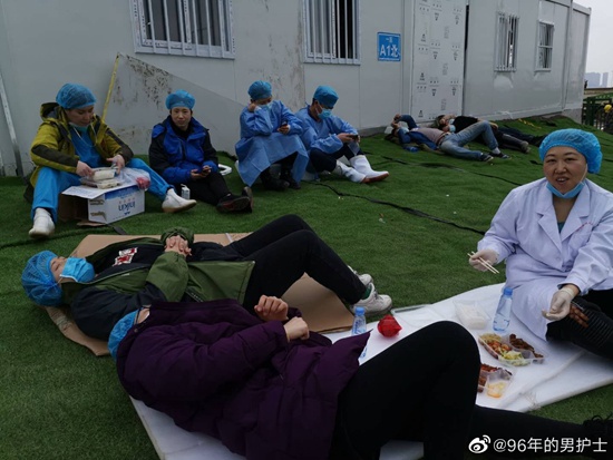 2月14日，武汉雷神山医院，辽宁医疗队队员在布置病区的间隙小憩。@96年的男护士