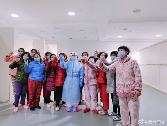 2月20日，武汉国际会展中心方舱医院，患者们与医护人员合影。@流云有颖