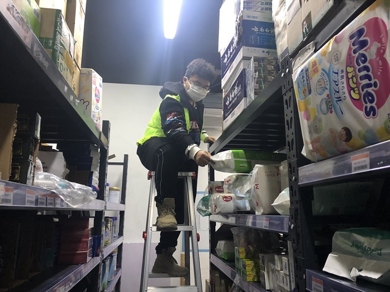 永辉生活福州市新店仓库里,志愿者叶键正在进行货物分拣补货.