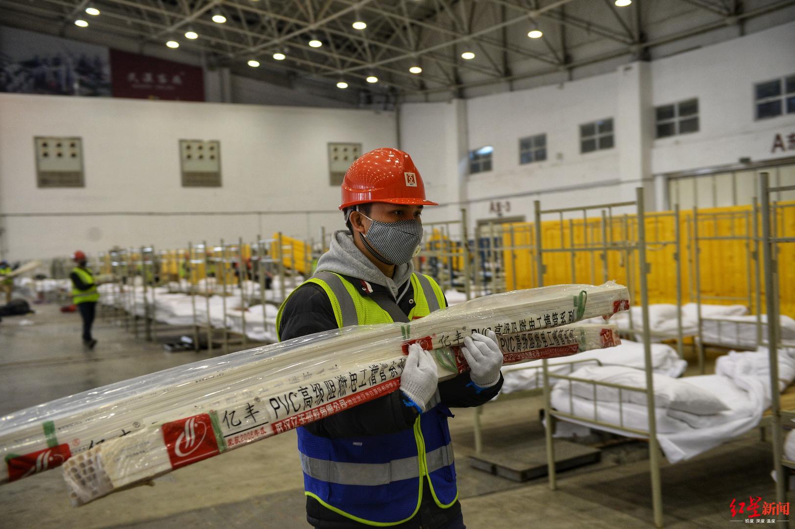 直击在建中的武汉"方舱医院":每张床铺配电热毯保暖