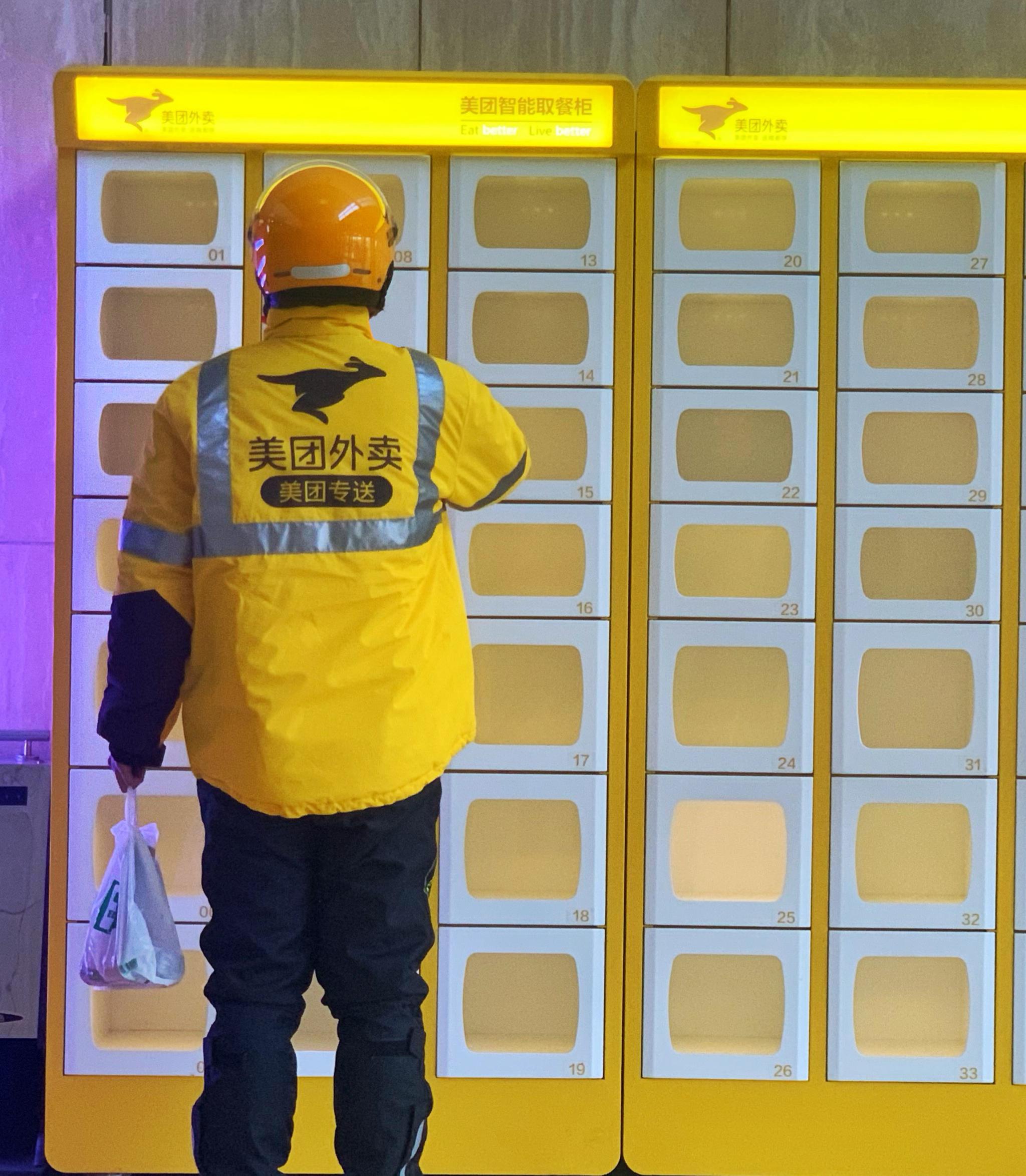 23岁的美团骑手徐发祥熟练地给配送箱和工作服喷好酒精消毒,戴上口罩