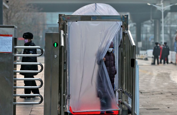 一位居民通过消毒棚进入小区。