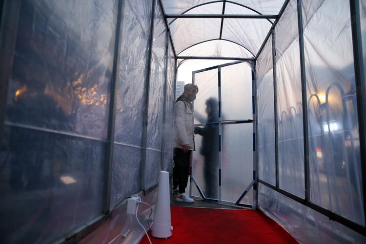 消毒棚内设置喷洒了84消毒液的地垫和加湿器。